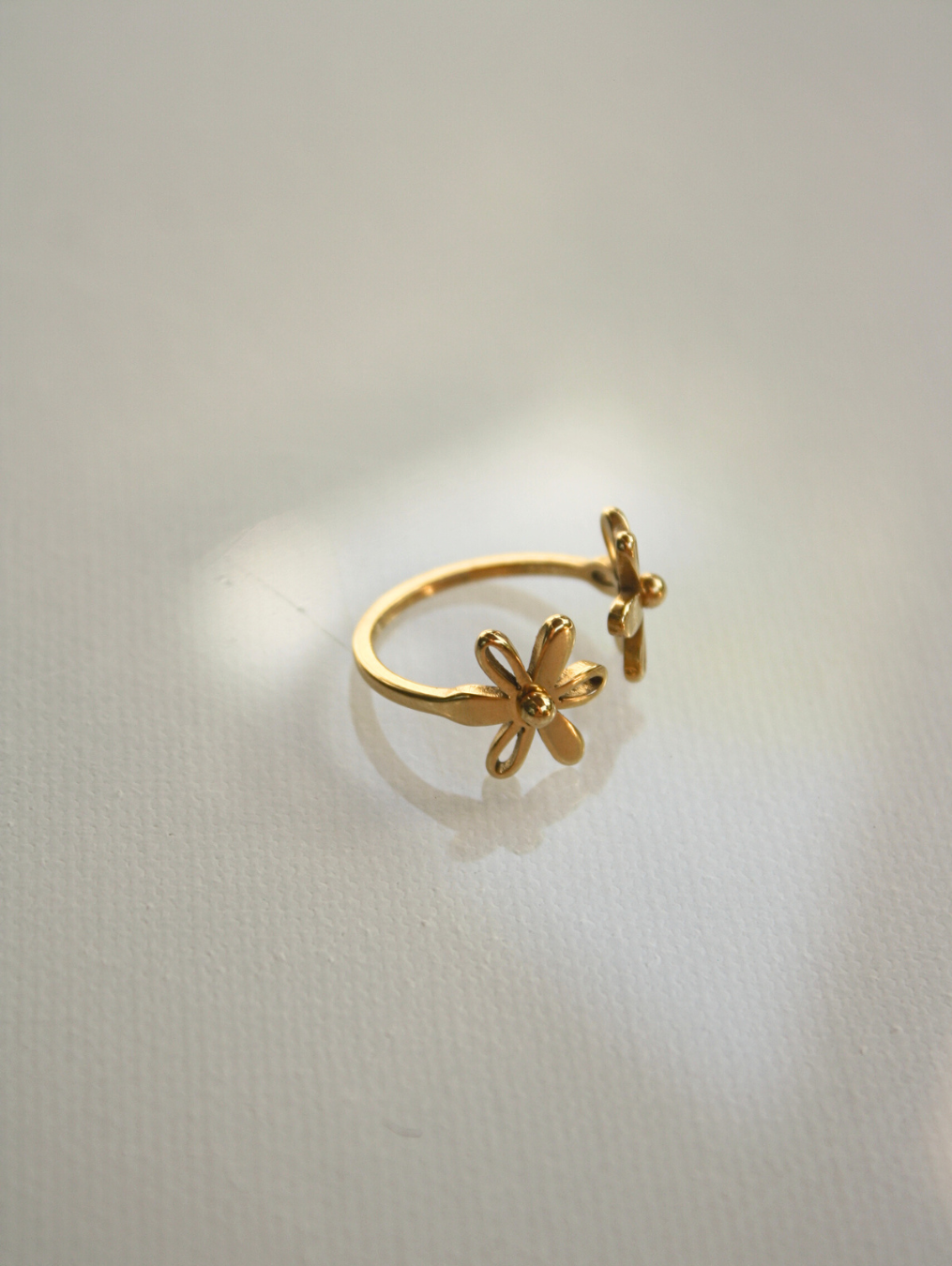 Gold ring with a butterfly design on a light gray background